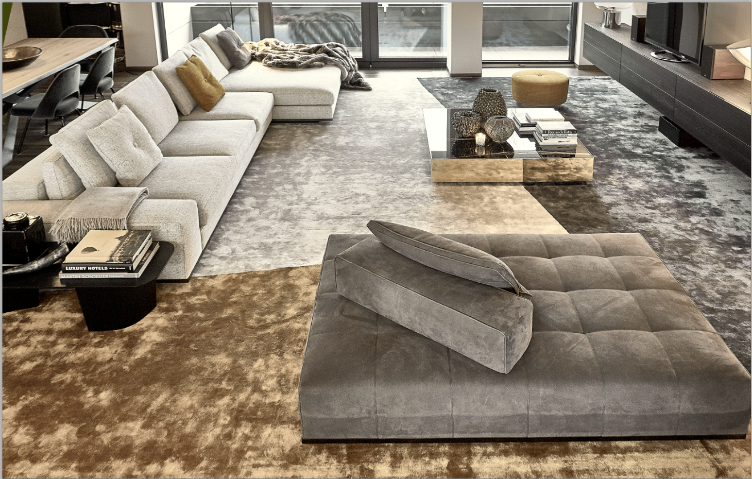 Spacious living room with oversized tricolor carpet and Minotti furniture